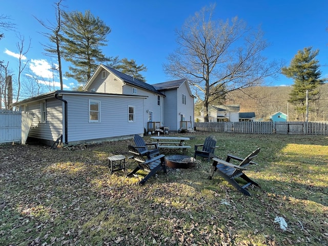 back of property featuring a yard and an outdoor fire pit