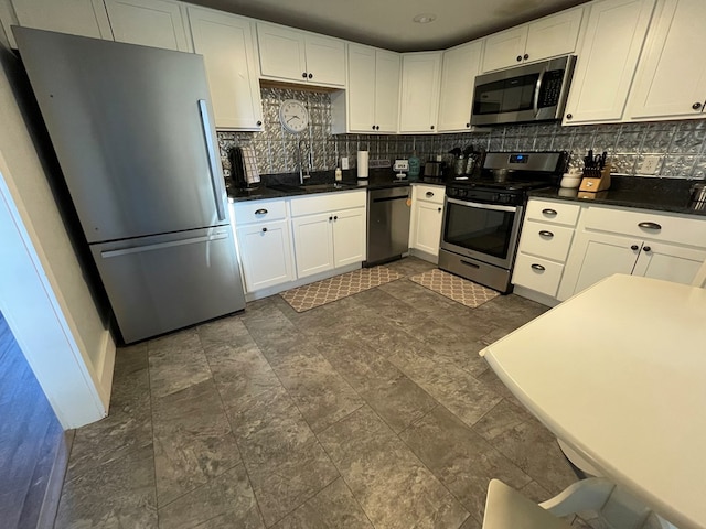 kitchen with decorative backsplash, white cabinetry, sink, and appliances with stainless steel finishes