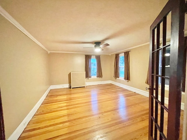 spare room featuring wood-type flooring, ceiling fan, and ornamental molding