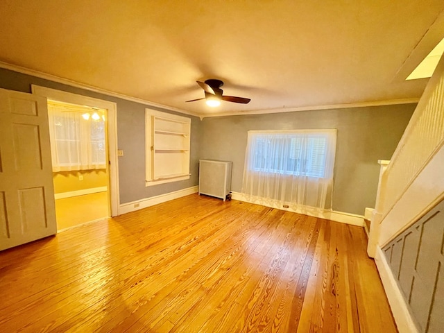 unfurnished room featuring built in shelves, ceiling fan, light wood-type flooring, and ornamental molding