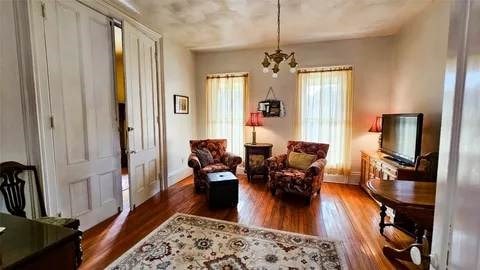 sitting room with wood finished floors and a notable chandelier