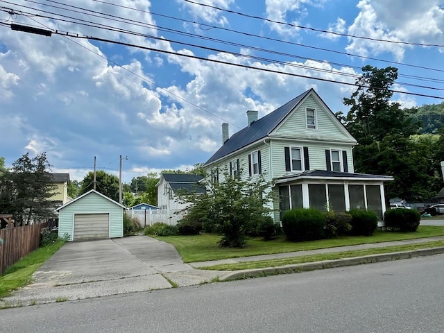 421 State St, Towanda, PA 18848 - view of front of house with driveway, a detached garage, an outbuilding, a sunroom, and a metal roof