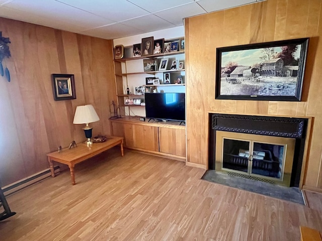 421 State St, Towanda, PA 18848 - living room with wood finished floors, a fireplace with flush hearth, baseboard heating, and wooden walls