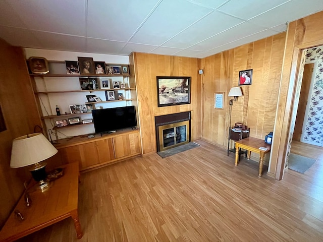 421 State St, Towanda, PA 18848 - living area with light wood-style floors, a fireplace with flush hearth, and wood walls