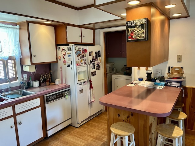 421 State St, Towanda, PA 18848 - kitchen featuring white appliances, white cabinetry, light wood finished floors, a breakfast bar, and washer and clothes dryer