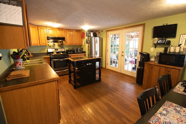 kitchen featuring hardwood / wood-style floors, french doors, a textured ceiling, and stainless steel appliances