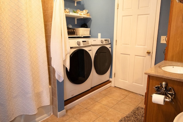 washroom with sink, washing machine and clothes dryer, and light tile patterned flooring