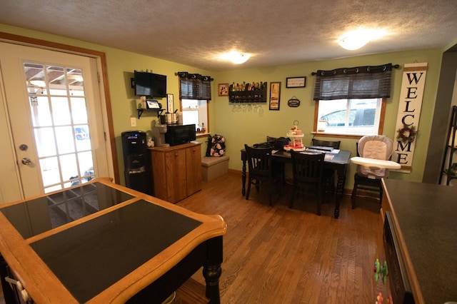 interior space with a textured ceiling and hardwood / wood-style floors