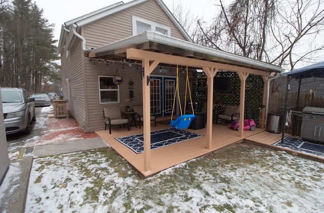 snow covered house featuring a deck