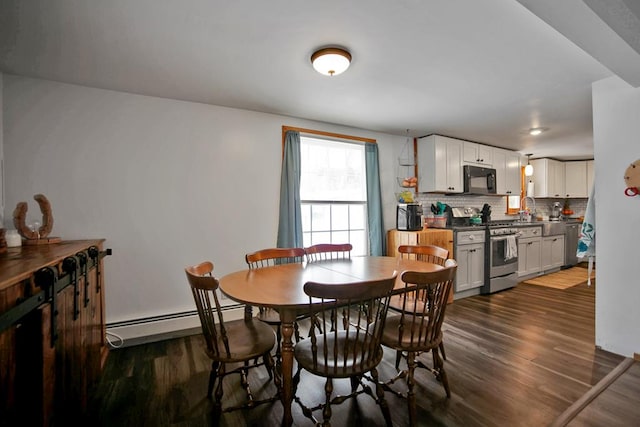 dining room with dark hardwood / wood-style flooring, sink, and a baseboard heating unit