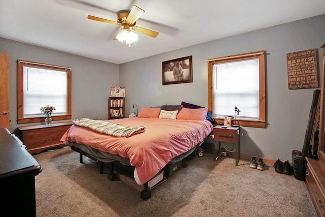 carpeted bedroom with ceiling fan and multiple windows