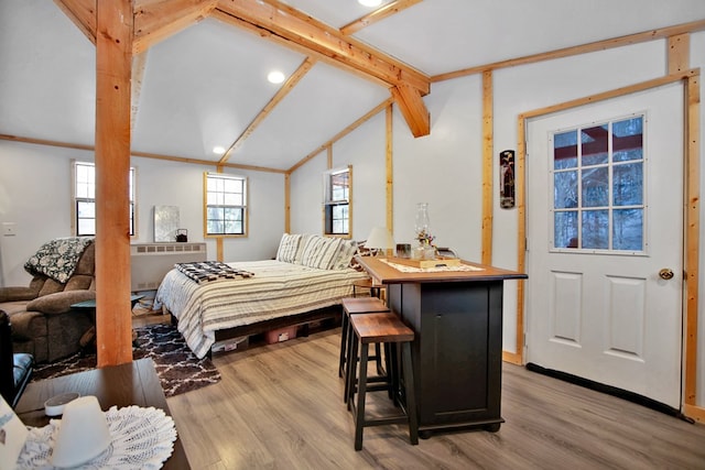 bedroom with hardwood / wood-style flooring and lofted ceiling with beams