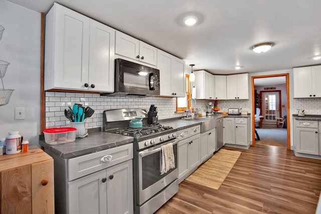 kitchen featuring white cabinets, appliances with stainless steel finishes, and dark wood-type flooring