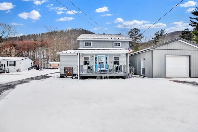 view of front of property featuring covered porch, an outdoor structure, and a garage