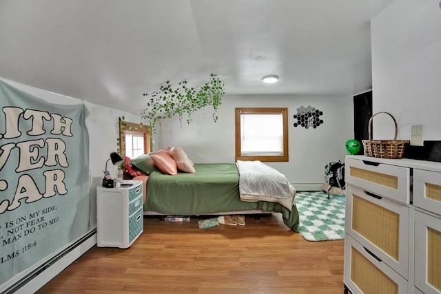 bedroom with light hardwood / wood-style flooring and a baseboard heating unit