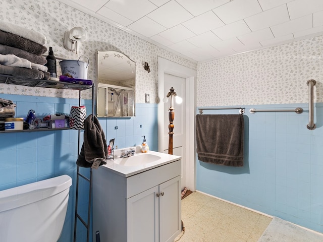 bathroom with vanity, toilet, and a shower with door