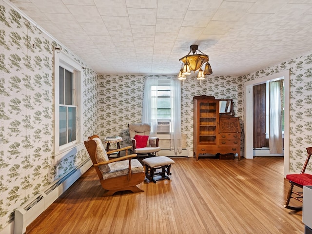 sitting room featuring hardwood / wood-style flooring and a baseboard heating unit