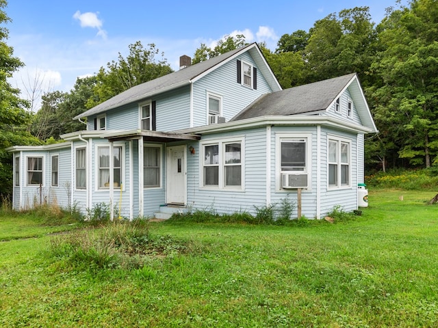 rear view of property with a lawn and cooling unit