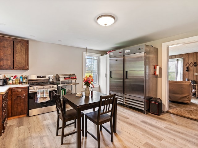 dining area with wooden walls and light wood-type flooring