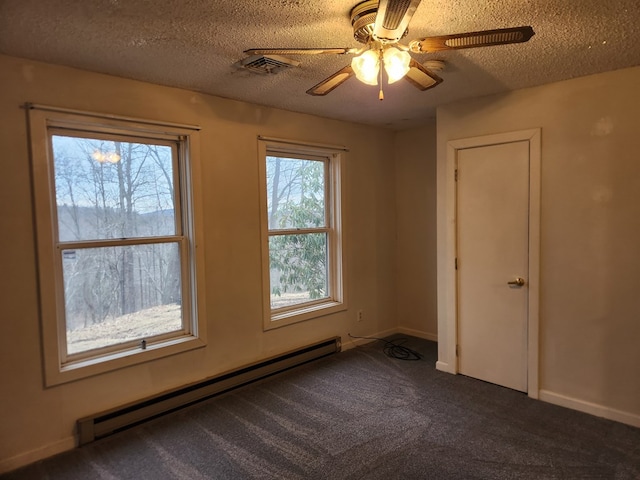 empty room with dark colored carpet, visible vents, a baseboard heating unit, a textured ceiling, and baseboards