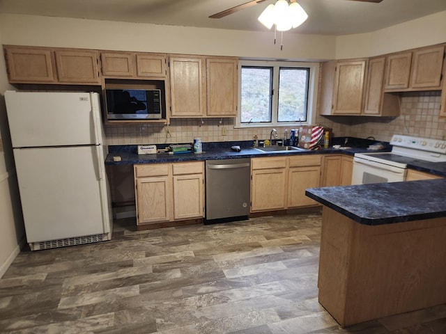 kitchen featuring dark countertops, white appliances, a sink, and decorative backsplash