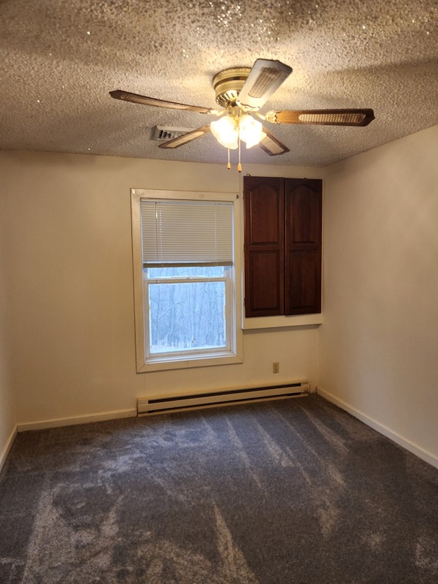 empty room featuring a baseboard radiator, baseboards, dark colored carpet, and a textured ceiling