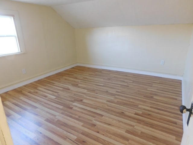 bonus room with lofted ceiling, wood finished floors, and baseboards