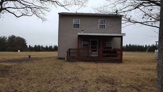 rear view of house featuring a lawn and a wooden deck