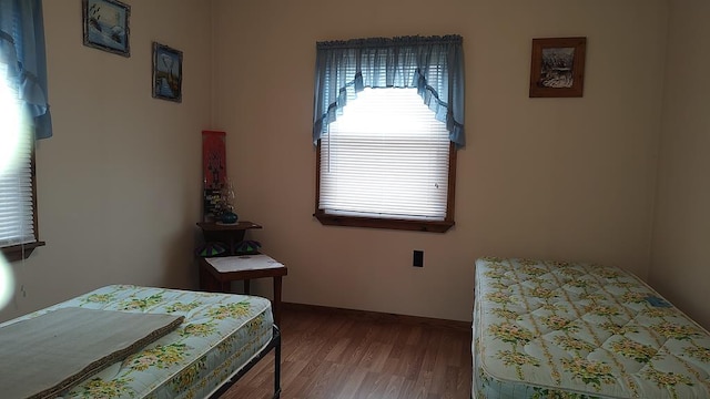 bedroom featuring wood finished floors and baseboards