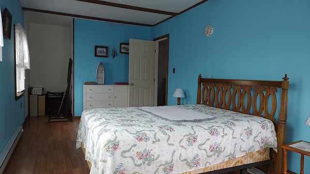 bedroom with a baseboard heating unit and wood finished floors