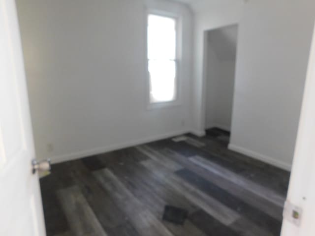 empty room with dark hardwood / wood-style flooring