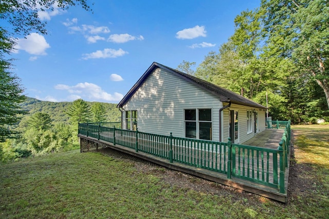 view of property exterior featuring a lawn and a deck