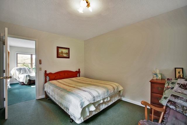 bedroom featuring dark carpet and a textured ceiling