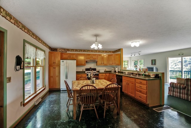 dining room with sink, a textured ceiling, and an inviting chandelier