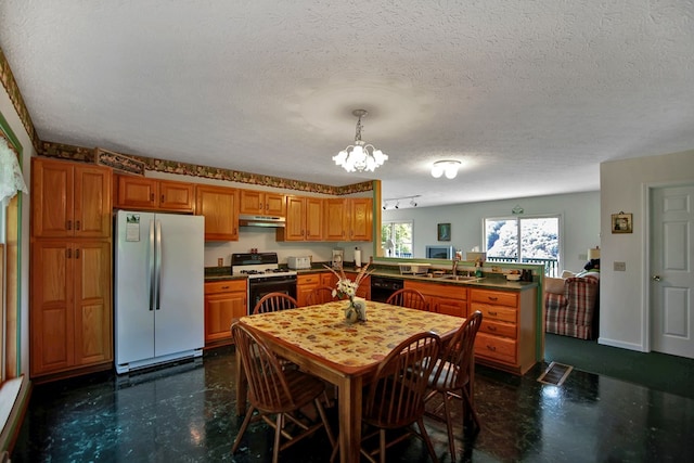 kitchen with white appliances, a textured ceiling, decorative light fixtures, kitchen peninsula, and a chandelier