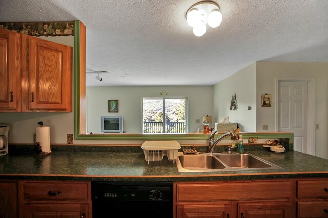 kitchen featuring a textured ceiling, dishwasher, kitchen peninsula, and sink