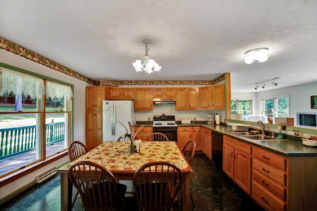 kitchen featuring sink, a notable chandelier, kitchen peninsula, pendant lighting, and white appliances