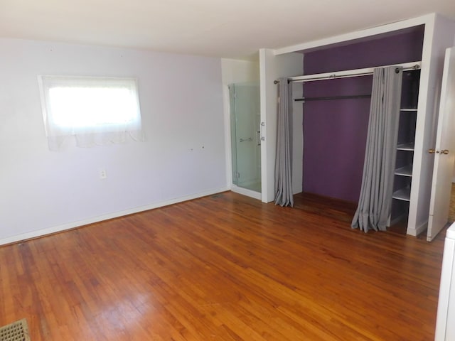 unfurnished bedroom with wood-type flooring and a closet