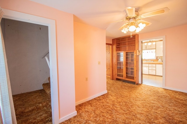 hallway with sink and light colored carpet