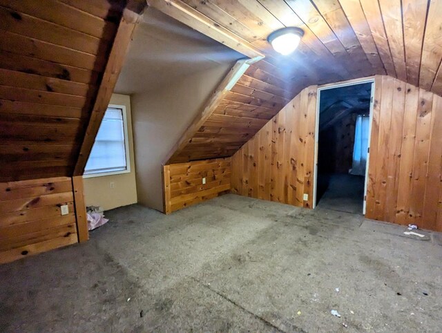 additional living space featuring vaulted ceiling, wooden ceiling, and wood walls