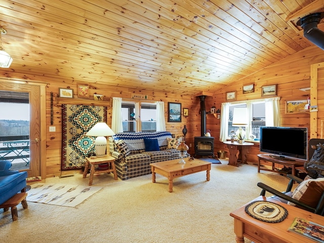 102-108 Fred Catlin Rd, Owego, NY 13827 - carpeted living area with wooden walls, plenty of natural light, a wood stove, and lofted ceiling
