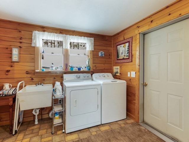 102-108 Fred Catlin Rd, Owego, NY 13827 - clothes washing area featuring washing machine and clothes dryer, a sink, wood walls, stone finish floor, and laundry area