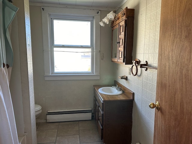 bathroom featuring toilet, vanity, tile walls, and a baseboard heating unit