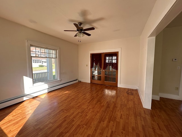 spare room with french doors, dark hardwood / wood-style flooring, baseboard heating, and ceiling fan