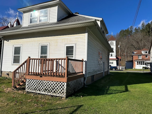 back of property with a lawn and a wooden deck