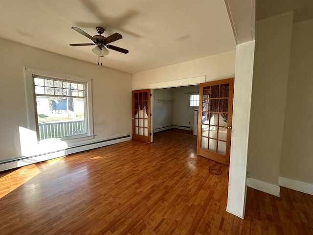 unfurnished room featuring french doors, dark hardwood / wood-style flooring, a baseboard radiator, and ceiling fan