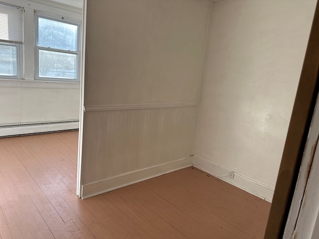 spare room with light wood-type flooring and baseboard heating