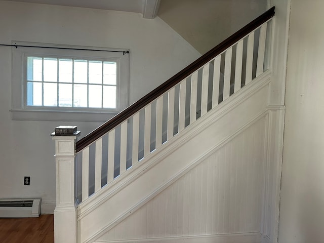 stairs with hardwood / wood-style floors and beamed ceiling