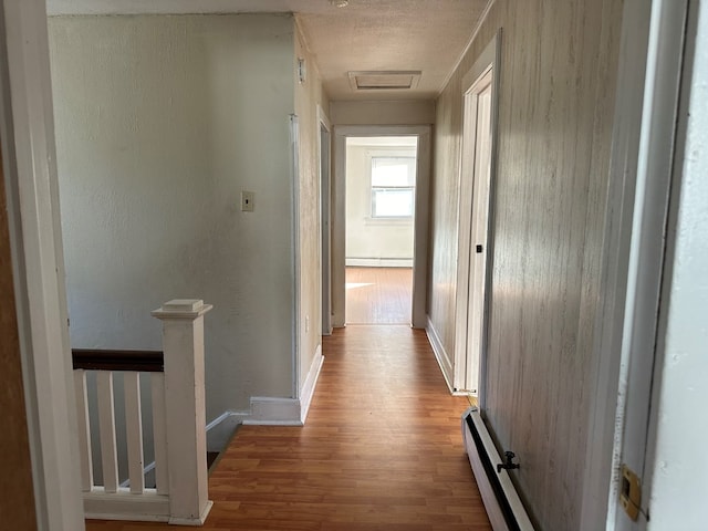 30 Turner St, Austin, PA 16720 - hallway with a baseboard heating unit, wood finished floors, baseboard heating, and an upstairs landing