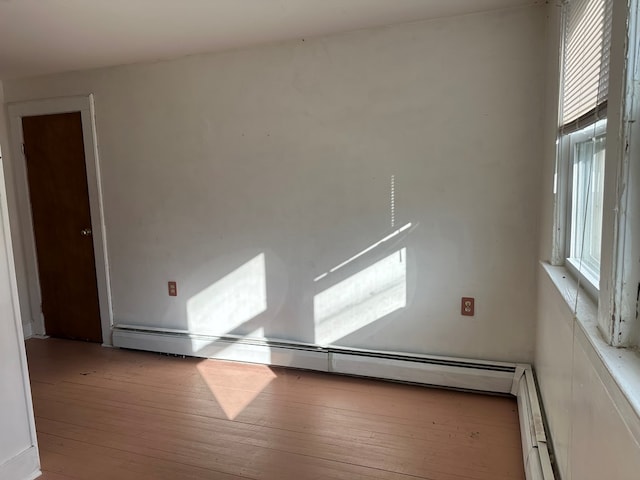 unfurnished room with light hardwood / wood-style flooring and a baseboard heating unit